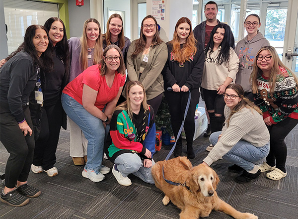 Sonny the therapy dog is the center of attention as Sophia Beydoun (far left) and her nursing class shower him with affection.