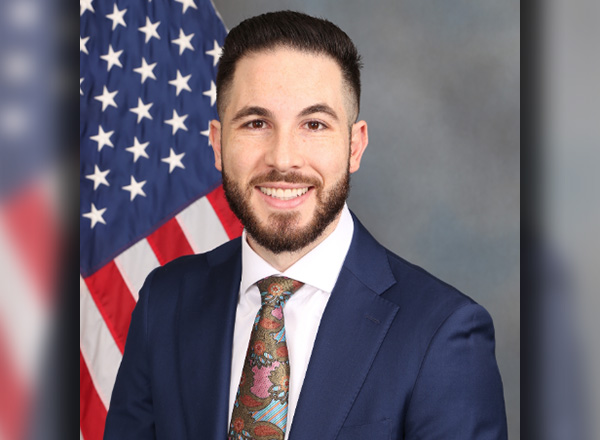 Dearborn Mayor Abdullah Hammoud headshot in suit with the American flag in the background.