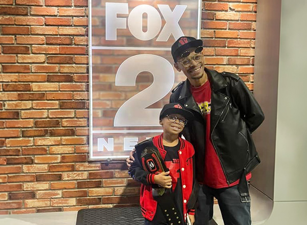 Houston, holding a wrestling belt, and his dad at the FOX 2 Detroit studios.
