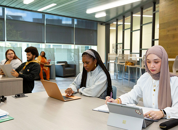 Students studying in wide open study space area.
