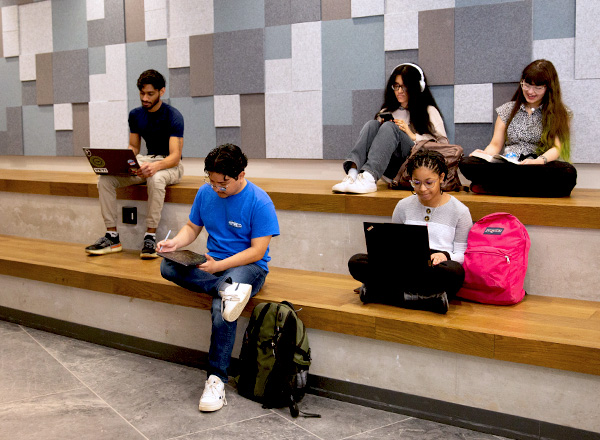 Students studying on study spaces bleacher like seating area.