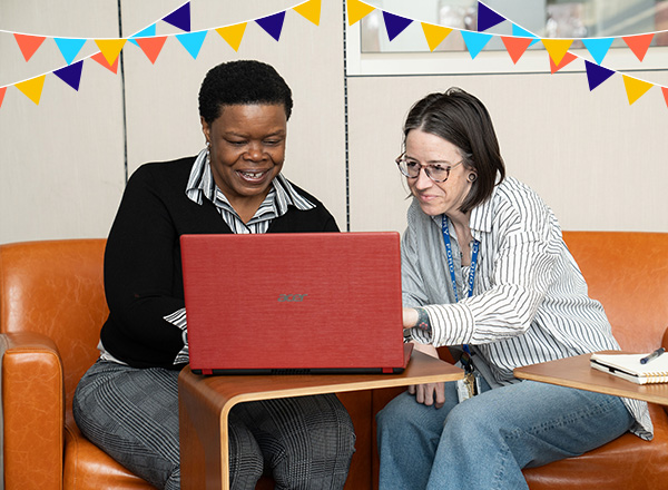 Writing Center staff assisting a student with illustrative banners above them.