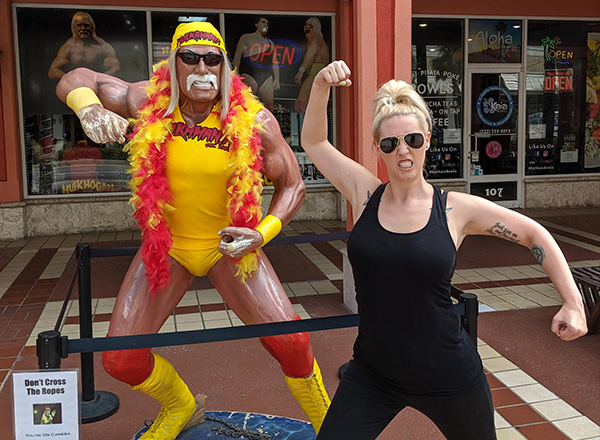 Stephanie Scicluna flexes alongside a likeness of wrestling legend Hulk Hogan.