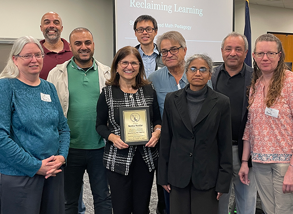 Mathematics faculty surrounding Nahla Haidar with her award.
