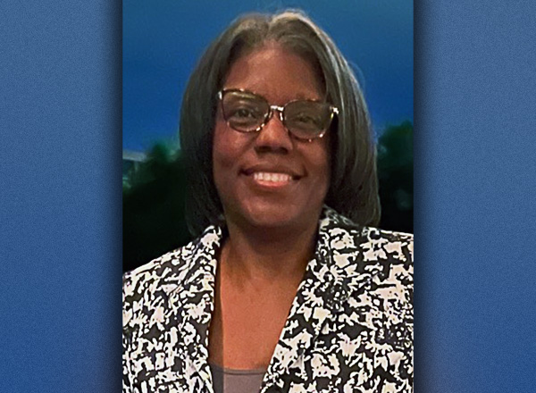 Close up of Alecia Carter with a blue background. 