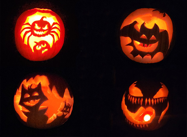 Four finished, lit jack-o-lanterns.