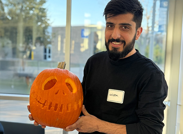 Student holding his completed carved pumpkin. 