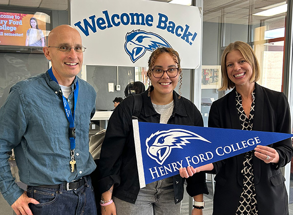 Tony Perry, an HFC student, and Dr. Lori M. Gonko pose with a Welcome Back sign and HFC pennant.