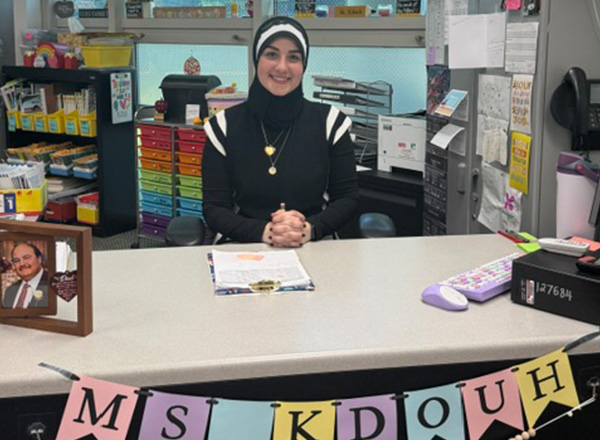 Sarah Kdouh at her desk in her classroom.