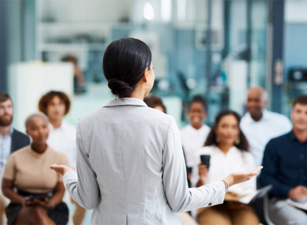 Woman presenting a workshop in front of a blurred audience