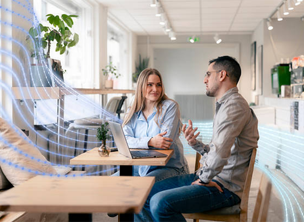 Casual business meeting in a bright co-working cafe with laptop and friendly discussion