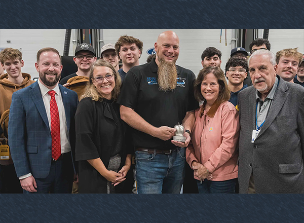 Large group of people, award winner holding award at center