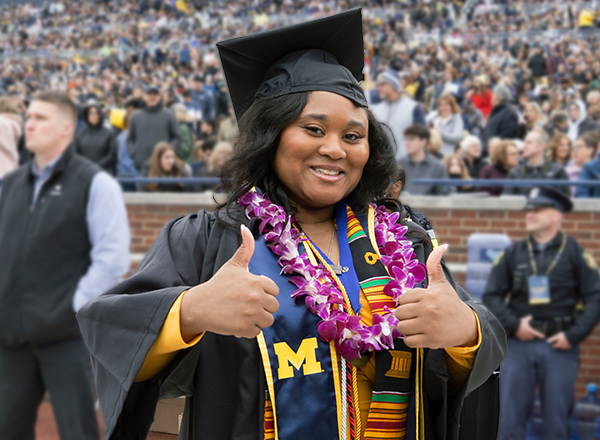 Alicia Jackson giving the thumbs up in her cap and gown.