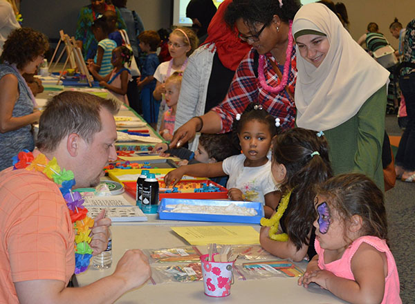Adults and children doing arts and crafts at tables