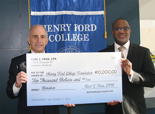 Karl Fava presents a $10,000 check to VP Reginald Best of the HFC Foundation