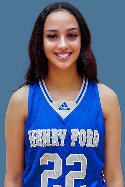 Portrait of Briana Ward in blue Henry Ford jersey on blue background