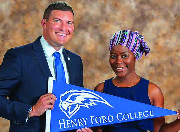 Russell Kavalhuna with a student holding an HFC Hawks banner.