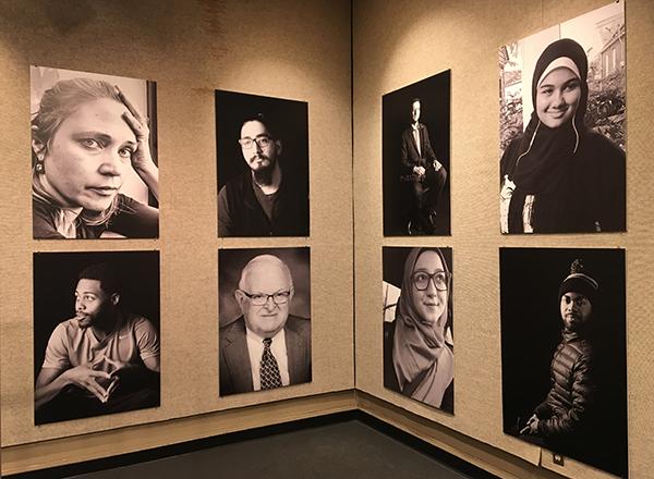 Eight large individual portraits displayed on the gallery wall at Sisson