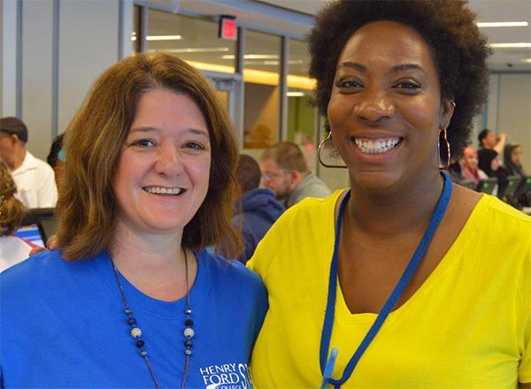 Two women standing side-by-side at the Welcome Center, smiling
