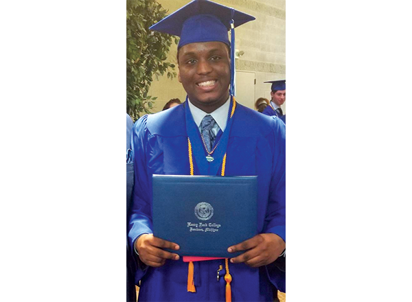Byron Brooks in his HFC regalia, holding his diploma