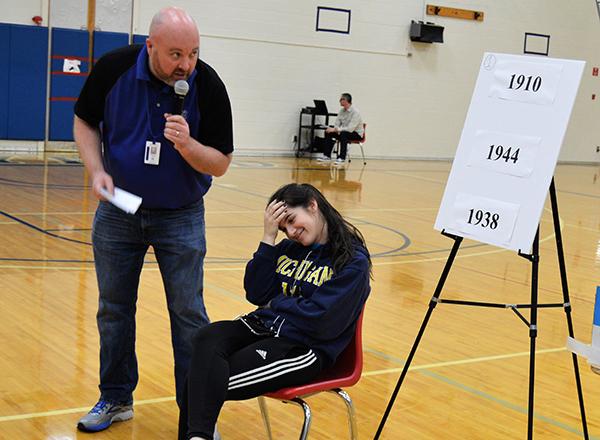 Chad Austin speaking to a student who's sitting in a chair at the DD opening ceremony. 