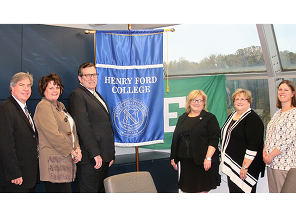 Six people standing beside HFC and EMU banners