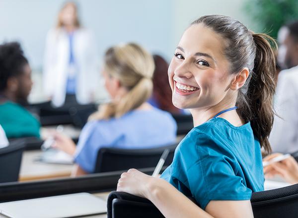 Female student turning around in her chair to smile at the camera