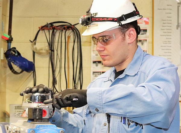 Chemical engineer in hardhat working on a machine