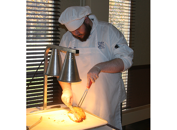 HFC student Robert Thacker carves meat during a buffet
