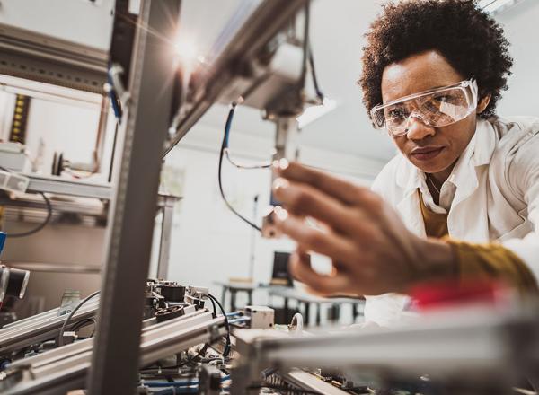 Woman wearing safety goggles working with machinery