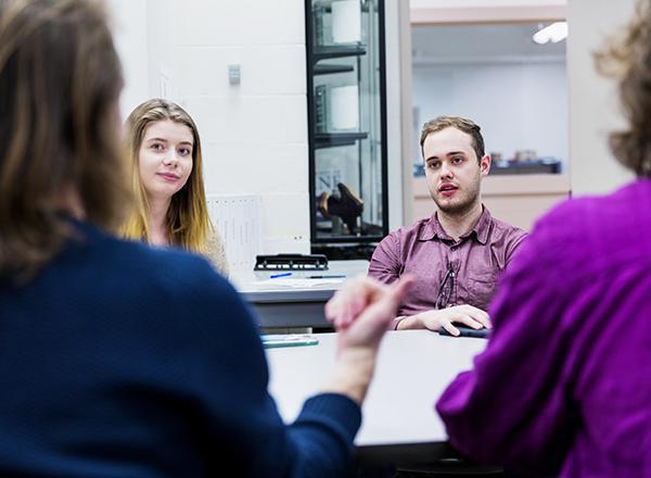 Students sitting side-by-side at a table