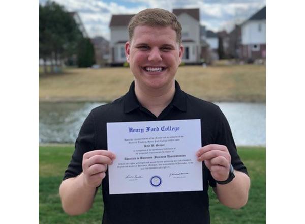 Photo of Grauer holding his HFC diploma