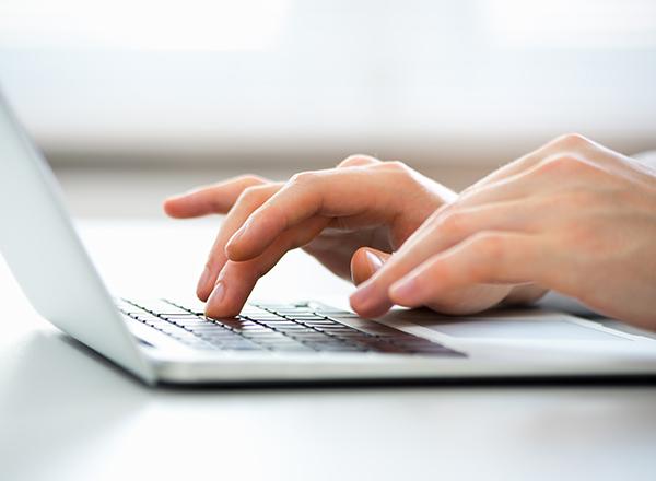 hands typing on a laptop