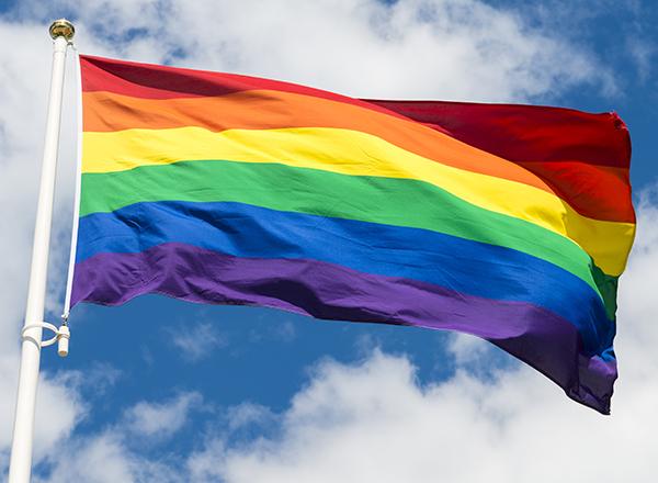 Rainbow flag against a blue sky