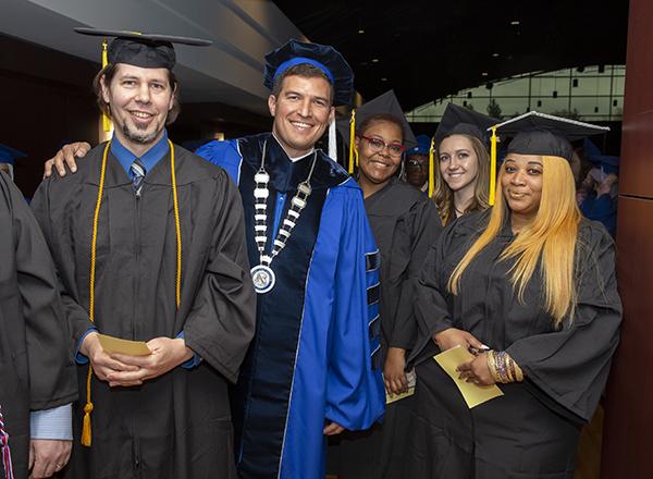 Five people in graduation regalia