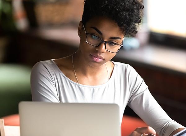 Female student studying, computer in foreground
