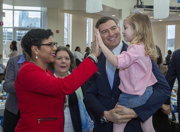 Sylvia Santana gives a high five to Samantha Kavalhuna (held by her father, Russ)