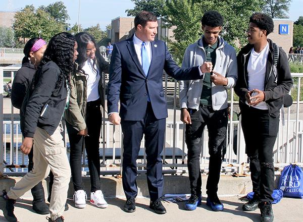 A group of people, two share a fist bump