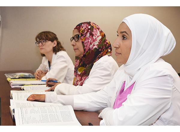 Photo of Lauren Fisher, Nudrat Jehan, and Halah Hassan in class