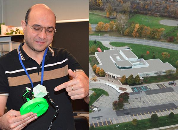 Dr. Hassan Nameghi, left, holds a “Scuumba,” an underwater vacuum robot used to clean fish tanks. This apparatus, created by HFC students in  fall  2019, is equipped with water jets to move it around the fish tank. At right is the M-TEC building, the new