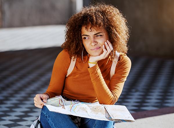 Student thinking, holding a map