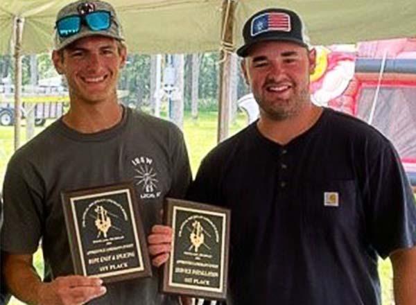 Henry Ford College alumni Nicholas Renner and Hunter James display their first place trophies.