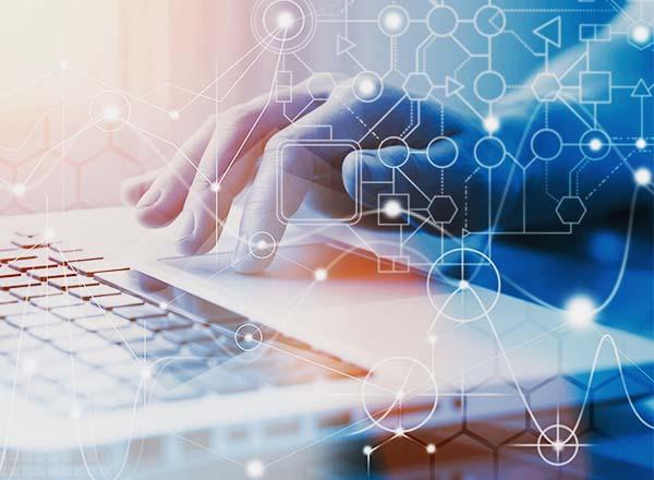 Hand on computer keyboard composited with line graphics of connecting shapes representing technology upgrades. 