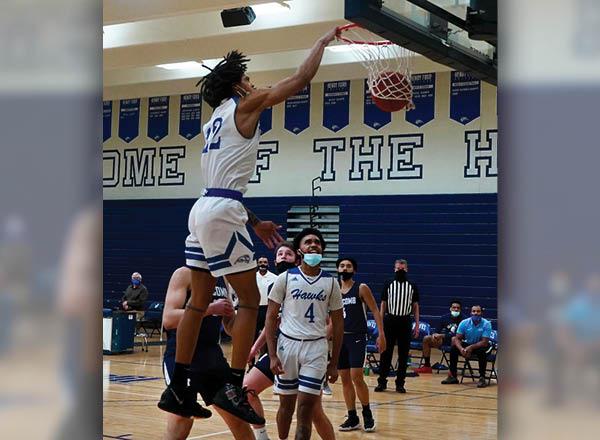An image of an HFC basketball player dunking a basketball. 