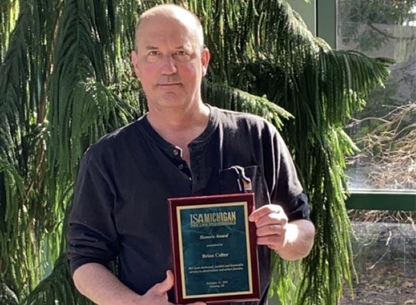 An image of Brian Colter holding his ISA award. 