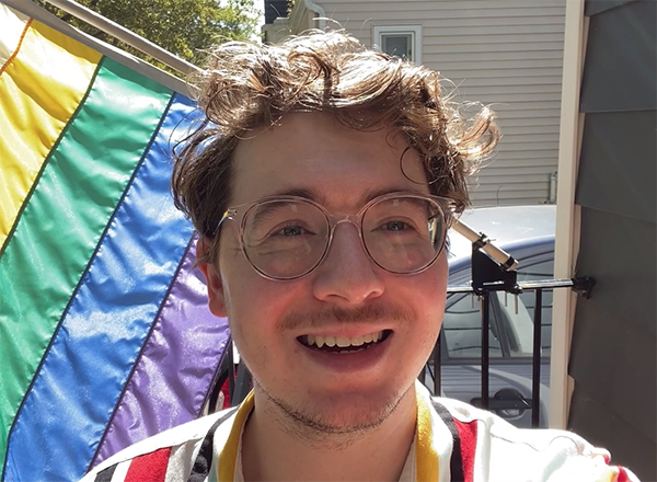 Eric Wilson in front of rainbow flag
