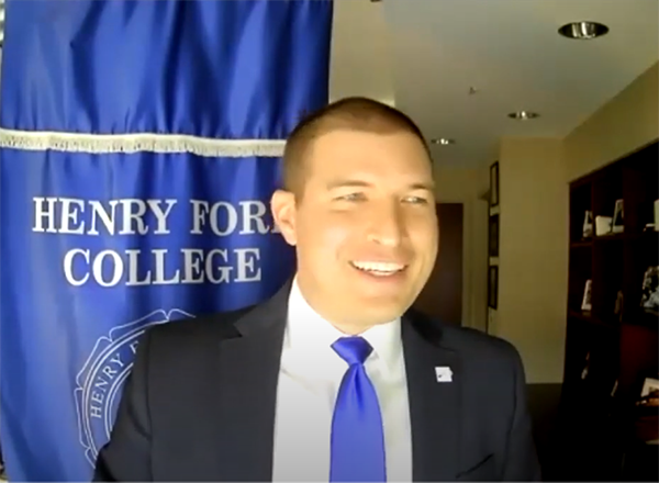 Photo of Russ Kavalhuna standing near HFC banner