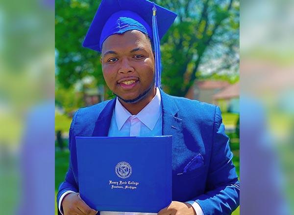 An image of Trevor McConico in his HFC graduation attire and holding his HFC diploma. 