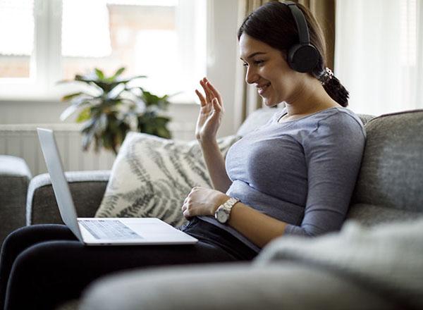 Young woman sitting at a computer on the couch. 
