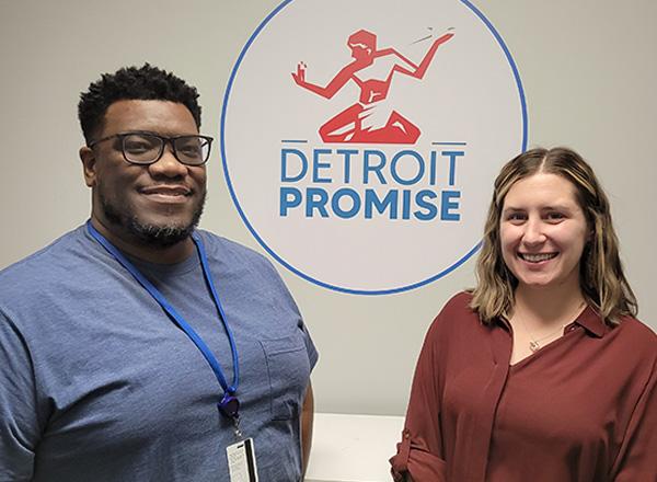 Photo of Yancy and Hogan in front of DP logo. 